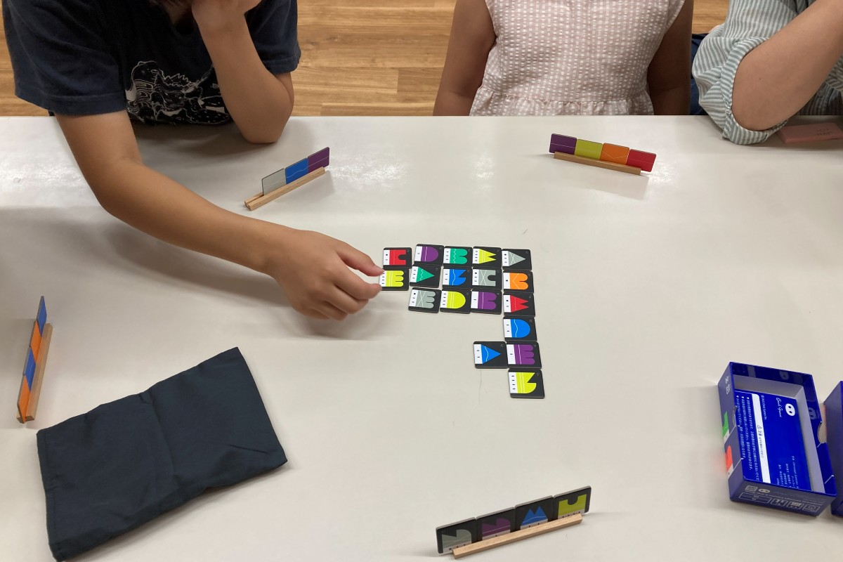 ボードゲームを使って対話しながら対局する子どもたち